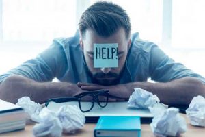 man with a post-it note that says help on his forehead