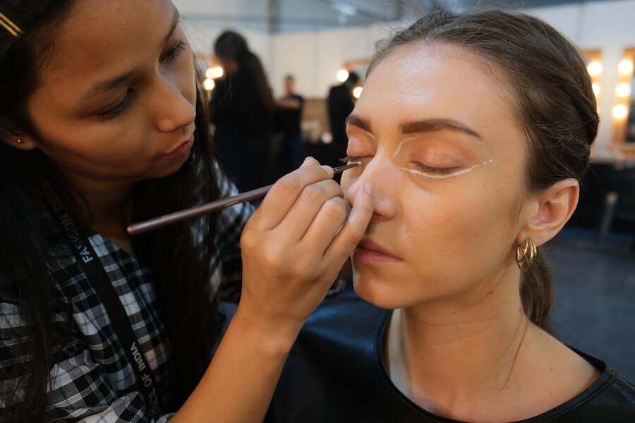 beauty artist applying makeup to a client