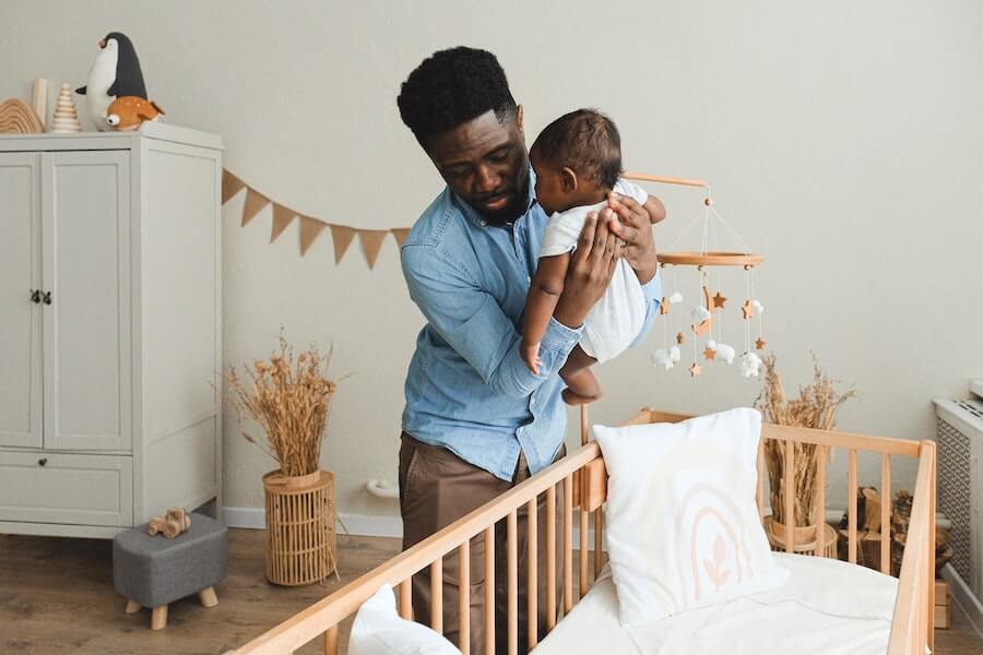 a childminder putting a baby to bed