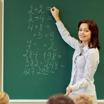 teacher writing in chalk on board