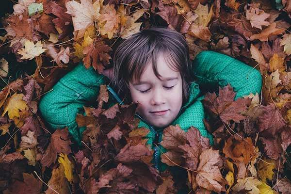 Child lying in leaves