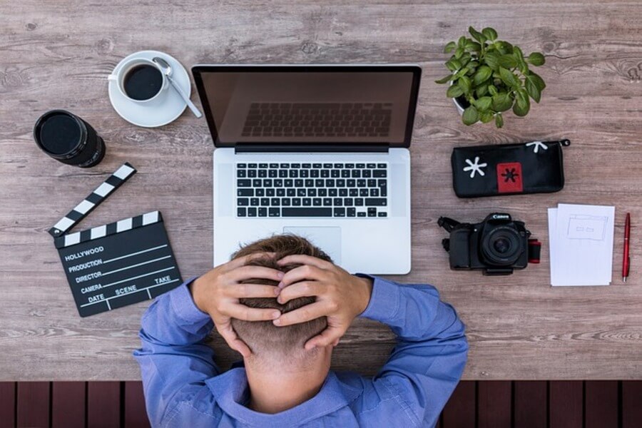 stressed man writing a resignation letter on his laptop