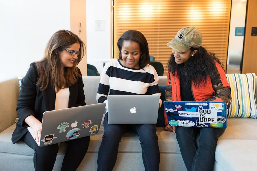 three students working on laptops for distance learning