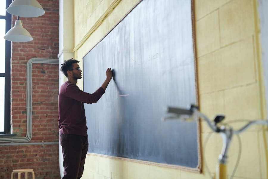 a teacher writing on a blackboard