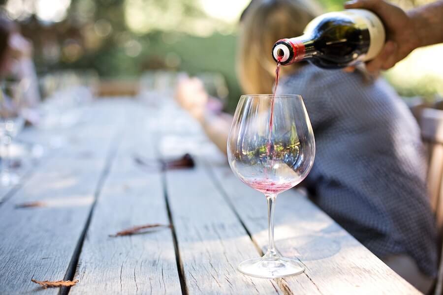 person pouring wine into a glass