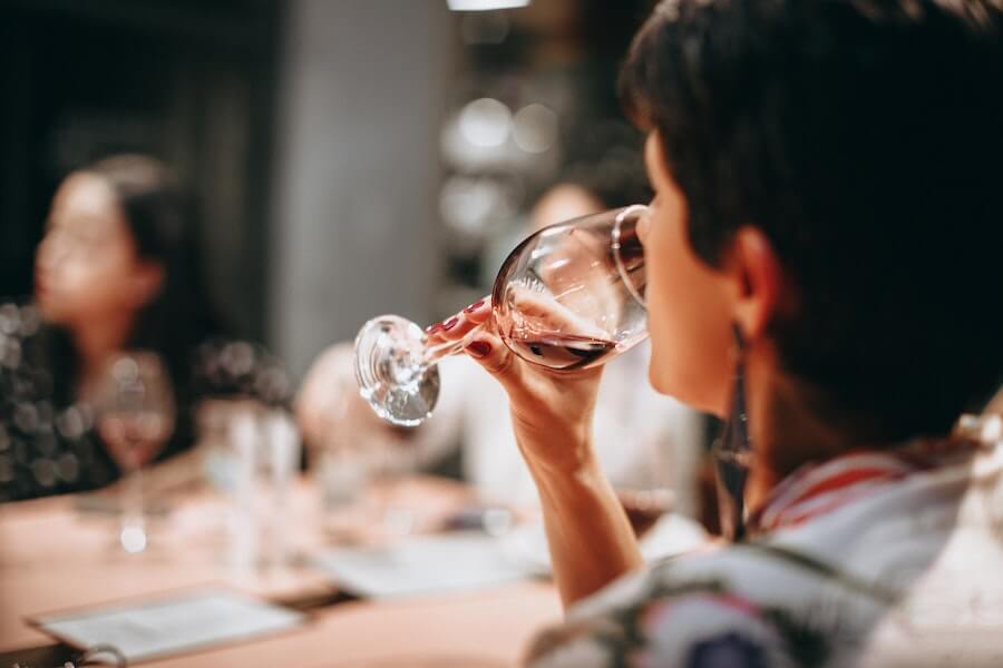 woman drinking alcohol at a dinner party