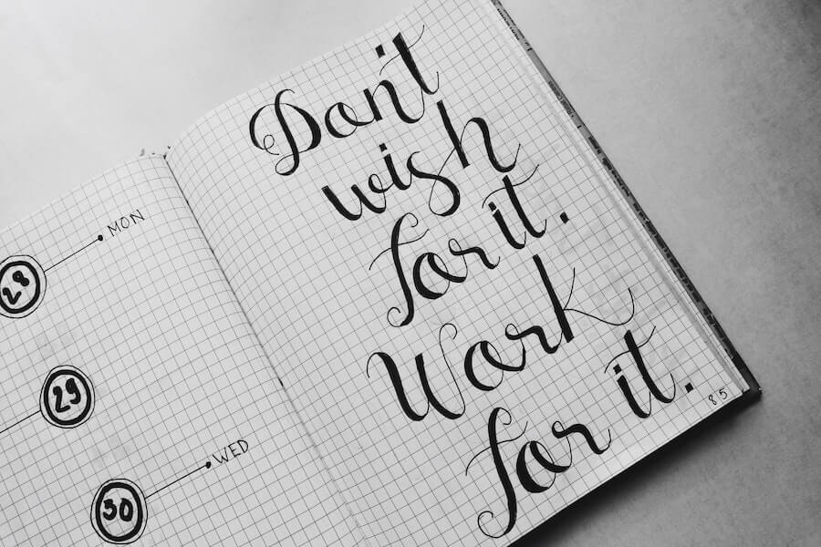 'don't wish for it. Work for it' written on notepad. Important info for aspiring to be a copywriter