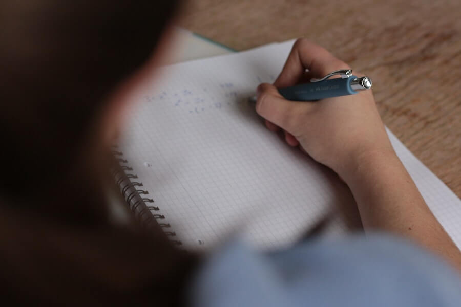 girl writing down facts for blurting revision