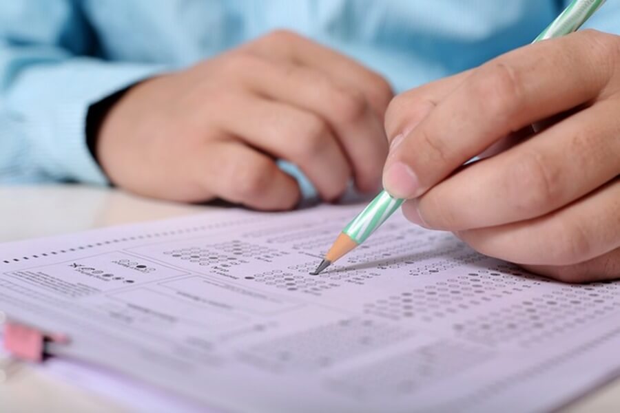 person filling out GCSE exams