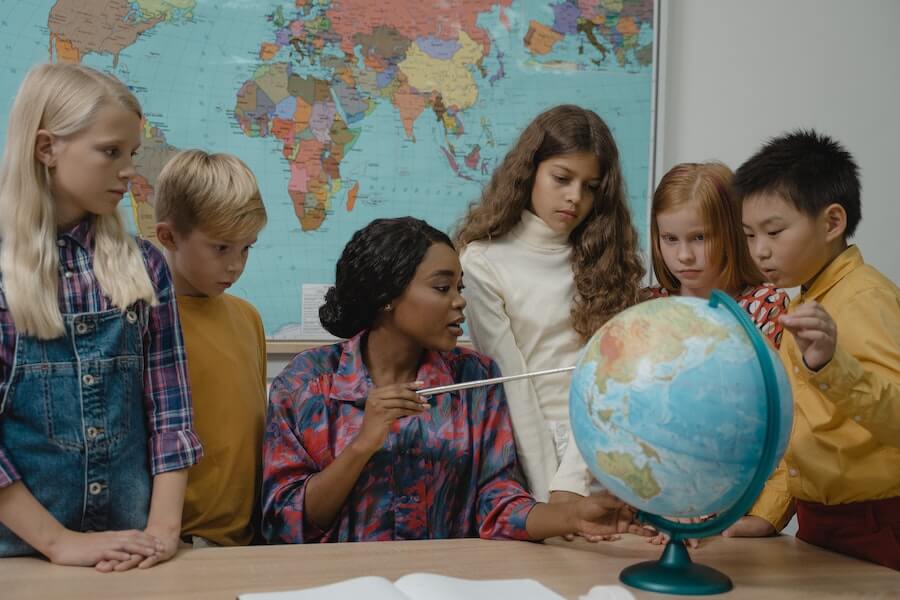 geography teacher without a degree teaching children with a globe