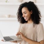 woman smiling at laptop after taking Myers Briggs personality test