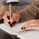 woman writing a personal development plan in a notebook