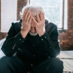 Man struggling to cope after redundancy with his head in his hands