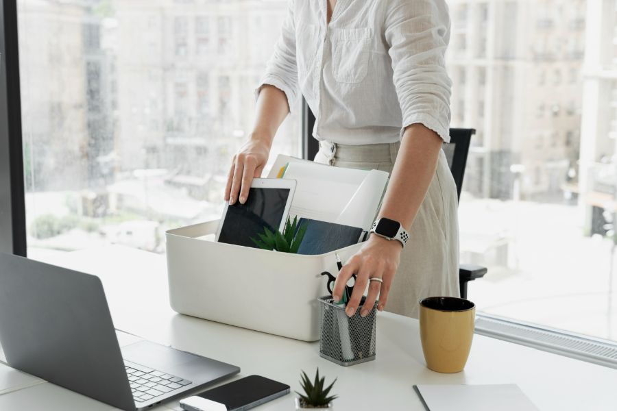 women packing her things away from her office desk after being redundant