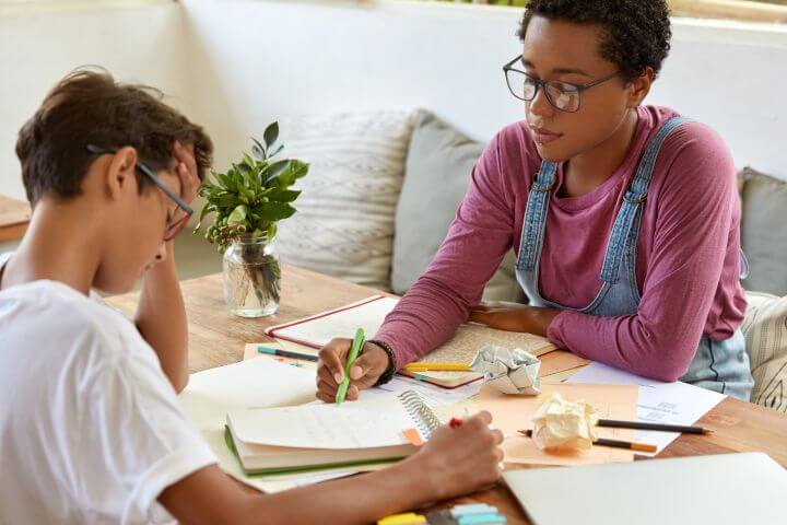 woman tutoring young school boy