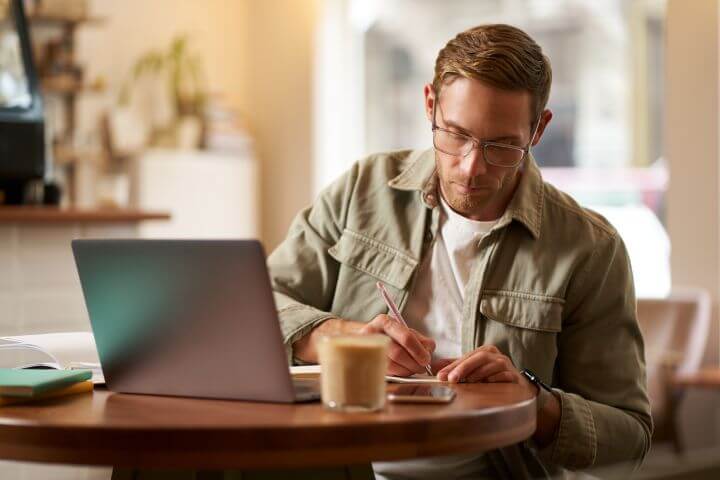 man carrying out freelance work in a cafe
