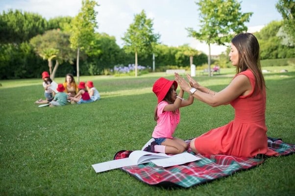 Childminder playing games with child in a park